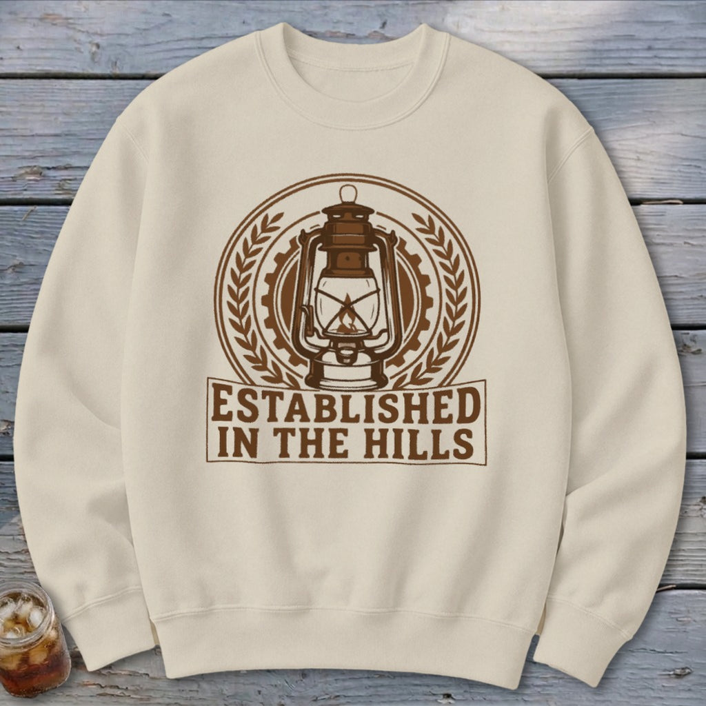 Cream sweatshirt with "Established in the Hills" text and a vintage lantern graphic.