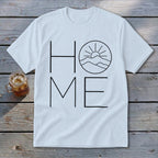 A white t-shirt featuring a black graphic that spells HOME, with a mountain and sun illustration replacing the letter O.