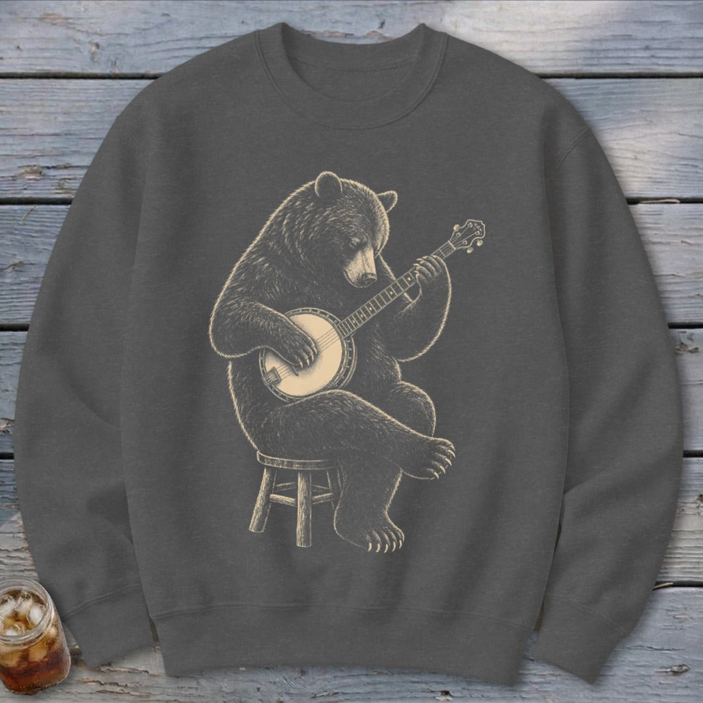 Bear playing a banjo while sitting on a stool, graphic design on dark gray sweatshirt.