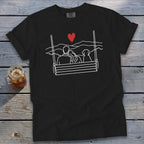 Black t-shirt with white line art of couple and dog on a swing, red heart above.