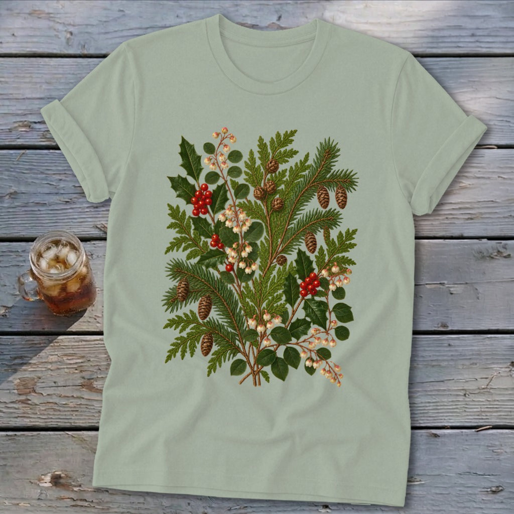 Light green t-shirt with a detailed botanical print of pine branches, holly, berries, and pinecones.