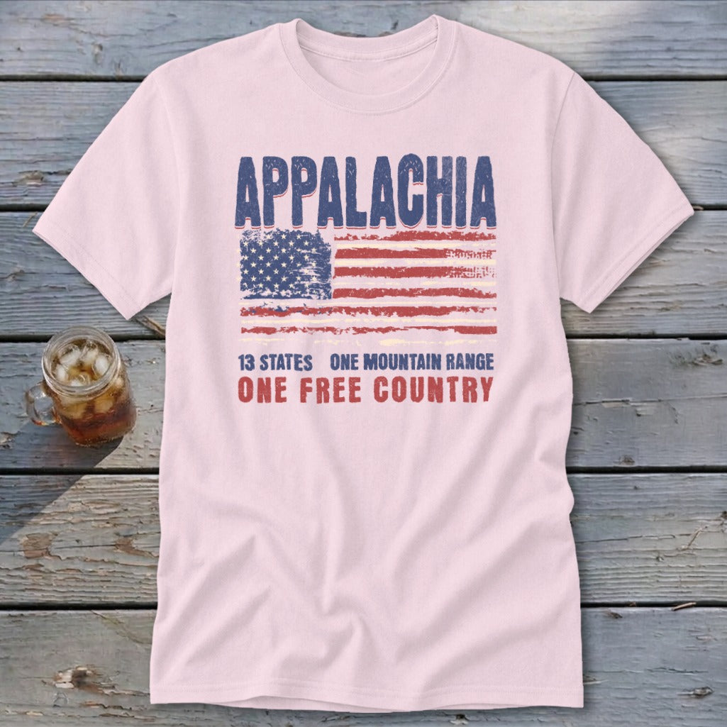 A light pink t-shirt featuring a distressed American flag graphic and text reading Appalachia, 13 States, One Mountain Range, One Free Country.