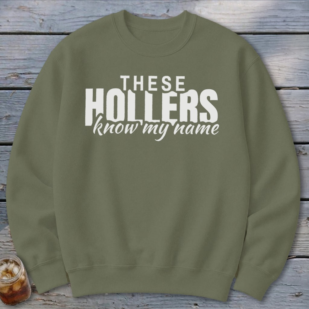 Green crewneck sweatshirt with "THESE HOLLERS know my name" white text.
