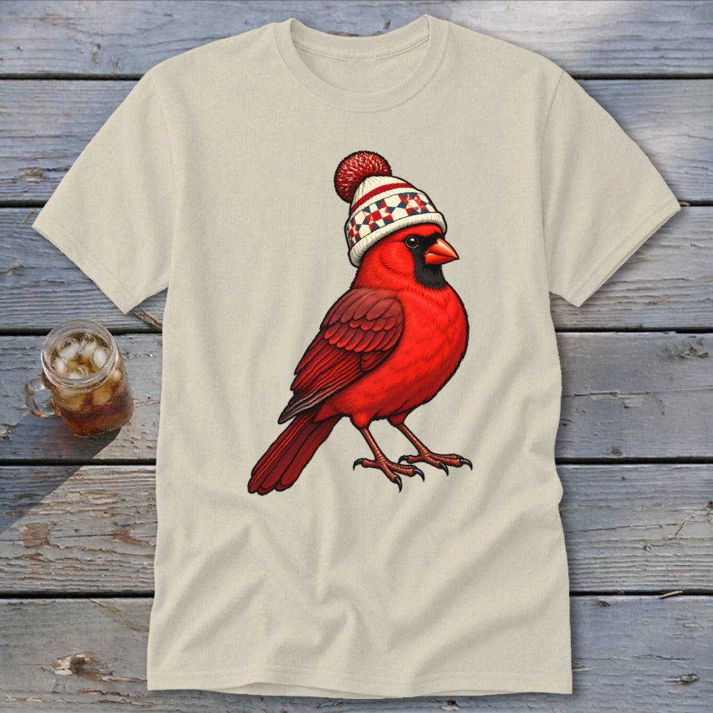 A cream-colored t-shirt with an illustration of a red cardinal wearing a winter beanie.