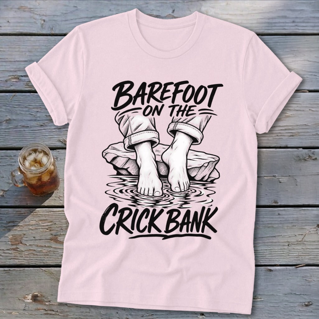 Pink t-shirt with graphic art of bare feet on rocks, "Barefoot on the Crick Bank" text.