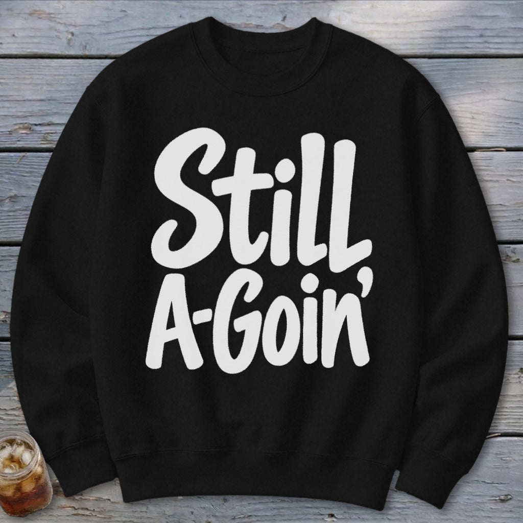 A black crewneck sweatshirt with the white text Still A-Goin centered on the chest.