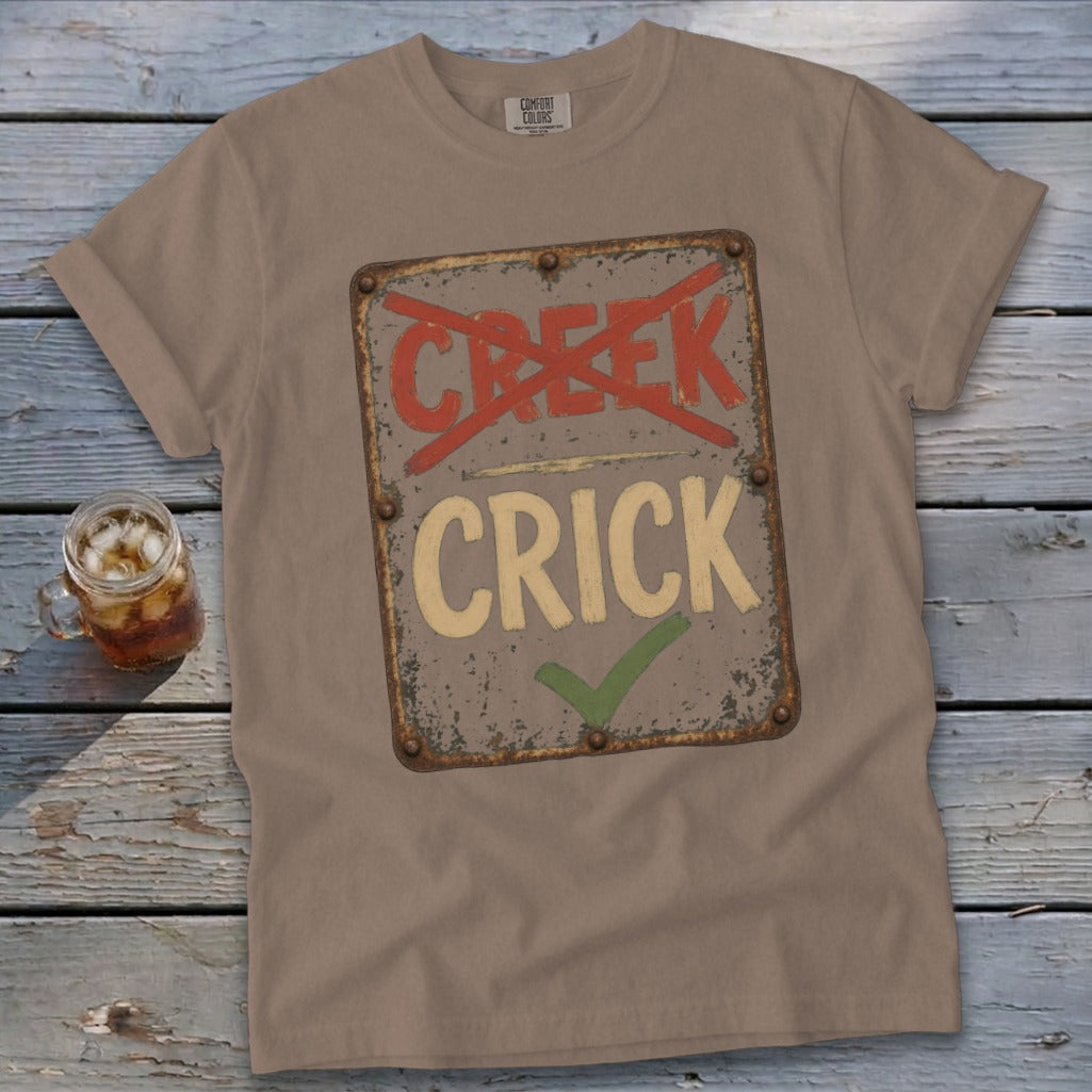 T-shirt with distressed sign reading "CREEK" crossed out and "CRICK" checked.