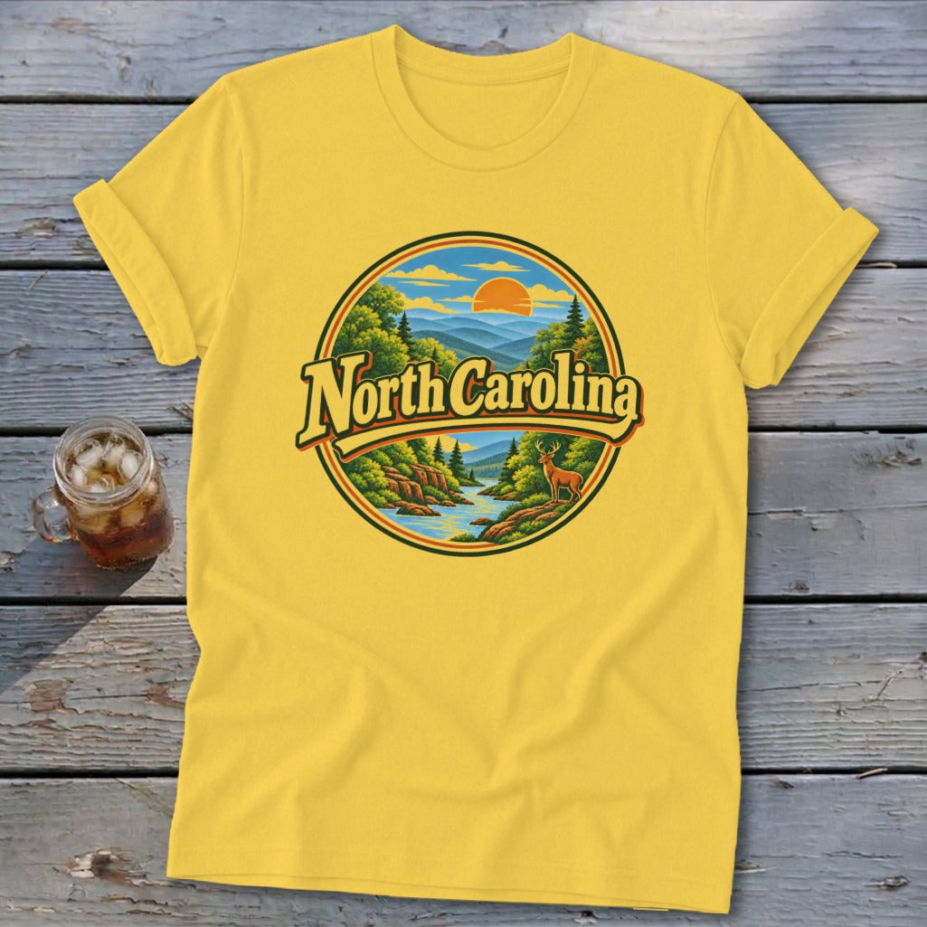 Yellow t-shirt with circular graphic of "North Carolina" over mountain river landscape and deer.
