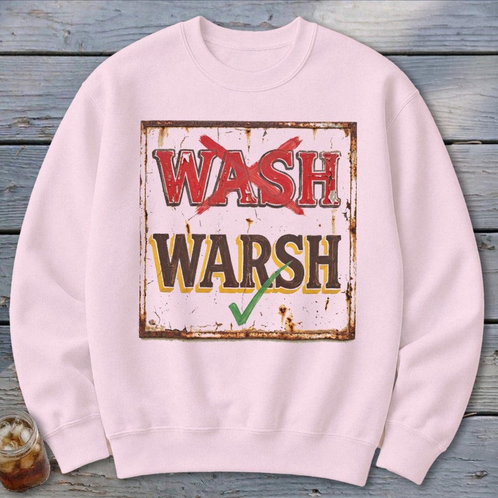 Light pink crewneck sweatshirt featuring a rustic sign graphic with the crossed-out text "WASH" and "WARSH" with a green checkmark.