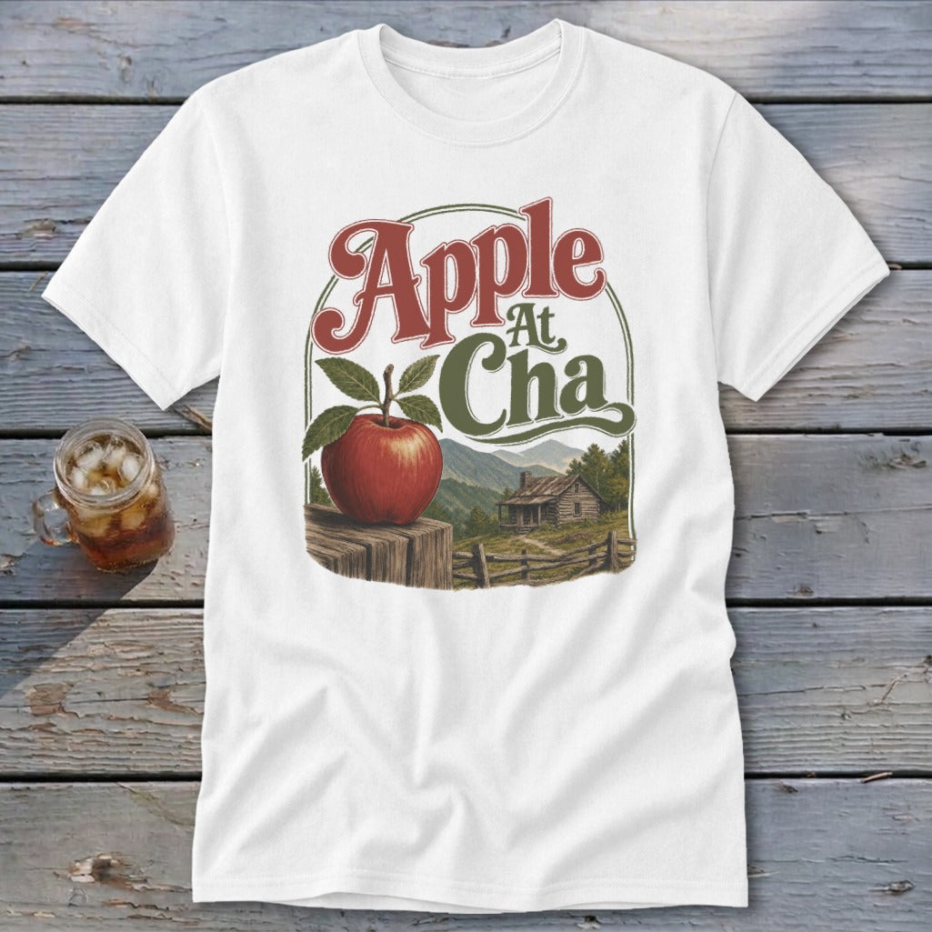 A white t-shirt featuring a retro graphic of an apple, a cabin, and the text Apple At Cha.