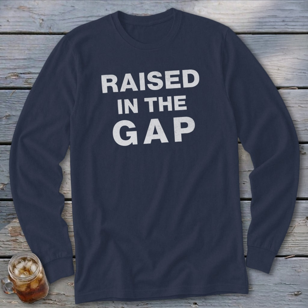 Navy long sleeve shirt with white text that reads "RAISED IN THE GAP".