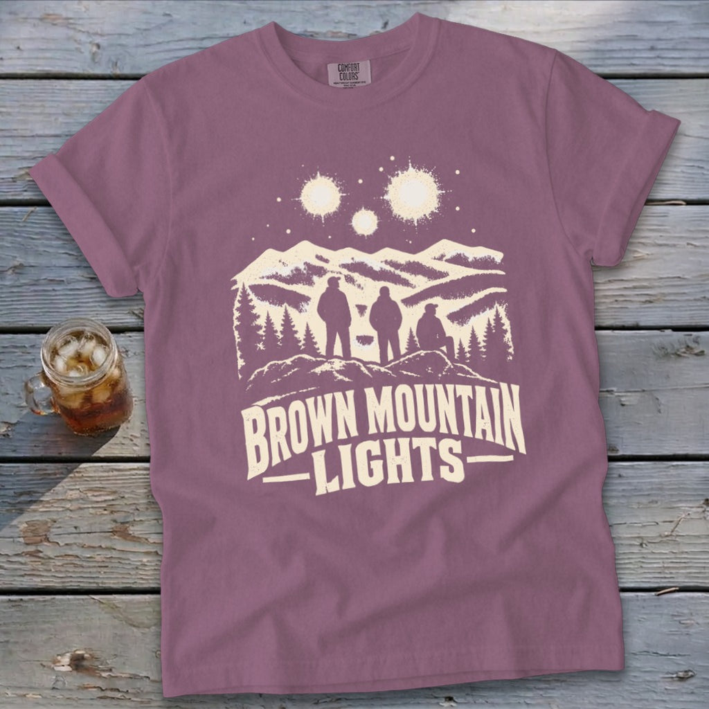 Mauve crewneck t-shirt featuring a graphic of three figures, mountains, and Brown Mountain Lights text.