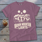 Mauve crewneck t-shirt featuring a graphic of three figures, mountains, and Brown Mountain Lights text.