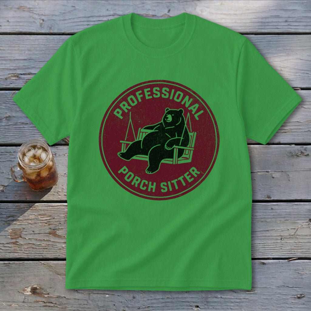 A green t-shirt featuring a circular graphic of a bear lounging on a swing with the text "Professional Porch Sitter."