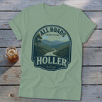 Light green t-shirt with a graphic of a winding mountain road and the text "ALL ROADS LEAD TO THE HOLLER".
