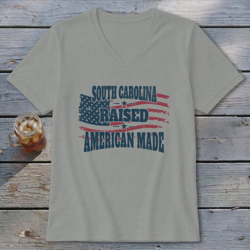 Light gray v-neck t-shirt with distressed American flag graphic and text "SOUTH CAROLINA RAISED AMERICAN MADE".