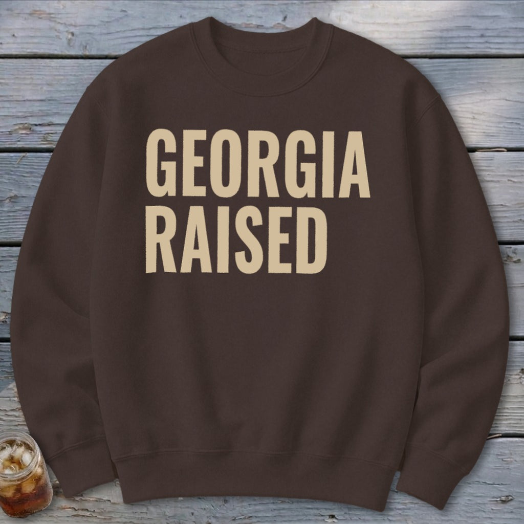Brown sweatshirt with "GEORGIA RAISED" printed in beige text.