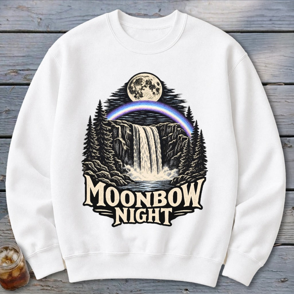 White sweatshirt with "Moonbow Night" text and waterfall, moonbow, and forest scene graphic.