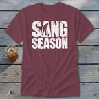 A maroon t-shirt with white distressed text reading "SANG SEASON" and a digger graphic.