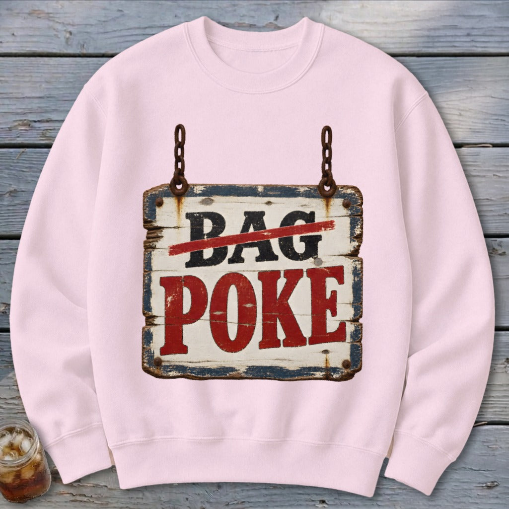 A light pink crewneck sweatshirt featuring a graphic of a rustic wooden sign that reads DAG POKE with the word DAG crossed out in red.