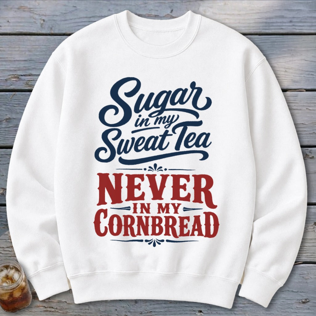 A white crewneck sweatshirt features blue and red typography reading "Sugar in my Sweat Tea Never in my Cornbread."