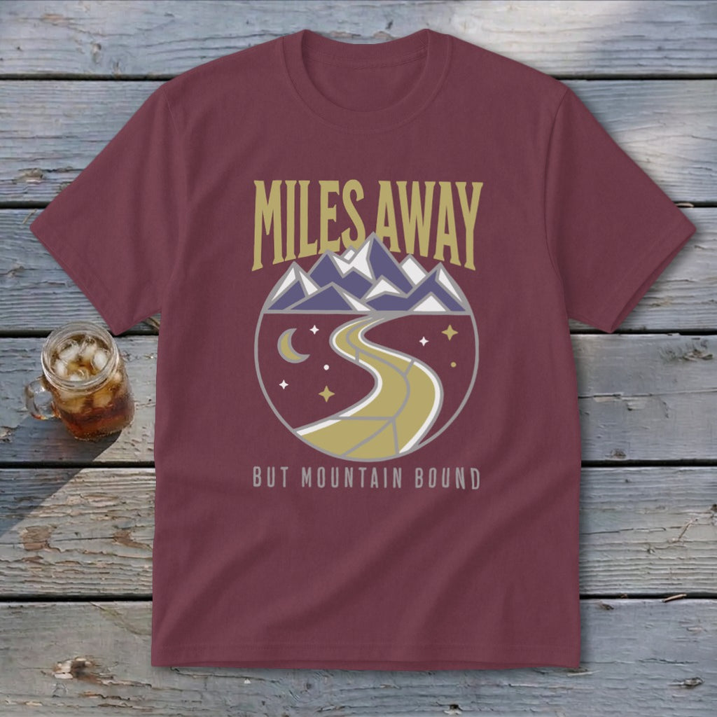 Maroon t-shirt with "Miles Away But Mountain Bound" text and mountain road graphic.