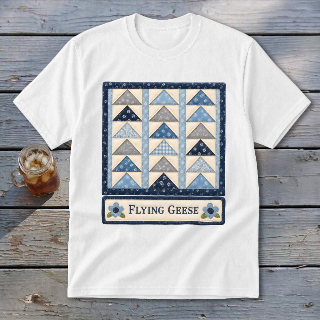 White t-shirt with a quilt design featuring blue and grey triangles and text "Flying Geese".