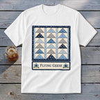 White t-shirt with a quilt design featuring blue and grey triangles and text "Flying Geese".