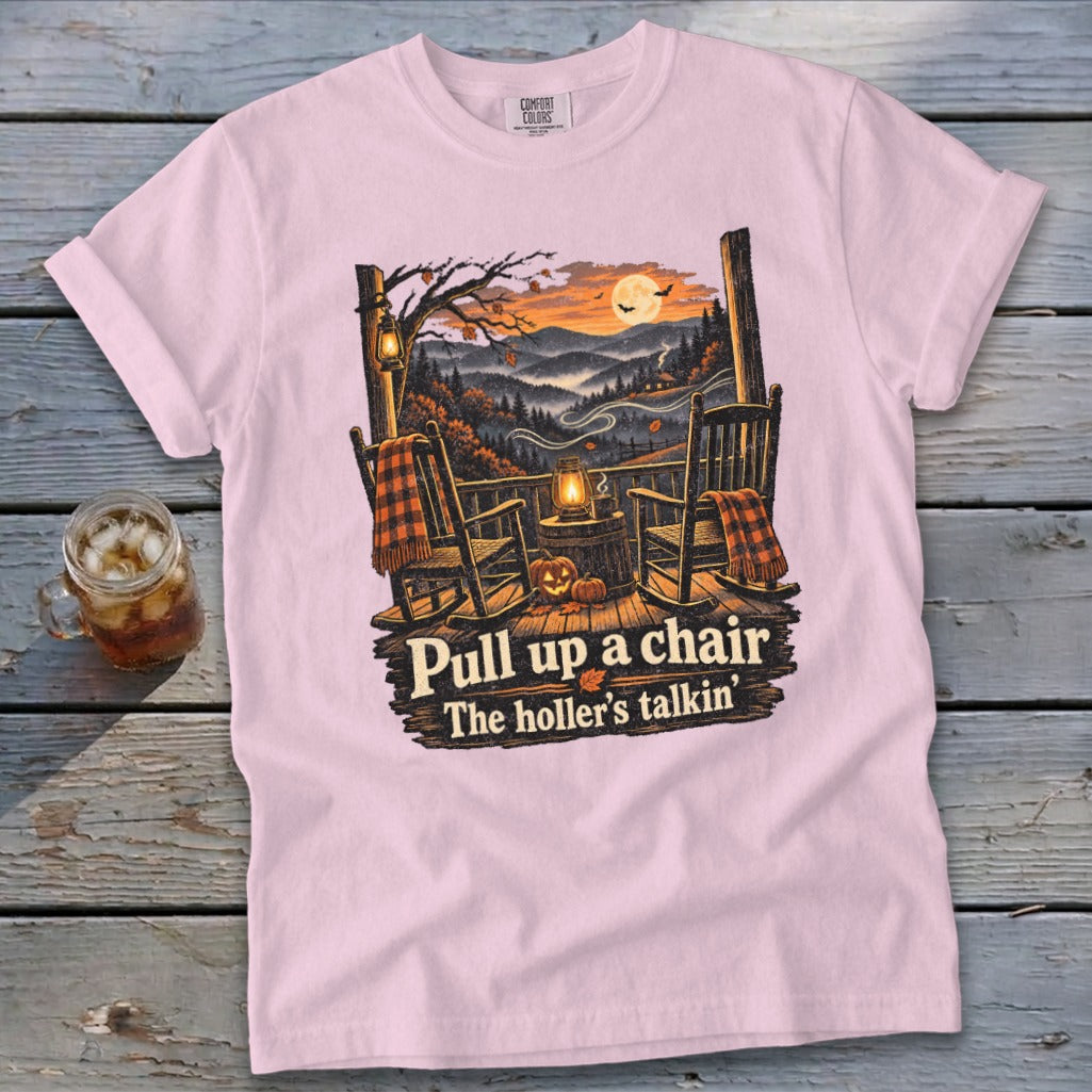 Pink t-shirt with porch scene and text "Pull up a chair The holler's talkin'".