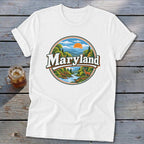 White t-shirt with circular Maryland graphic featuring mountains, river, deer, and sun.