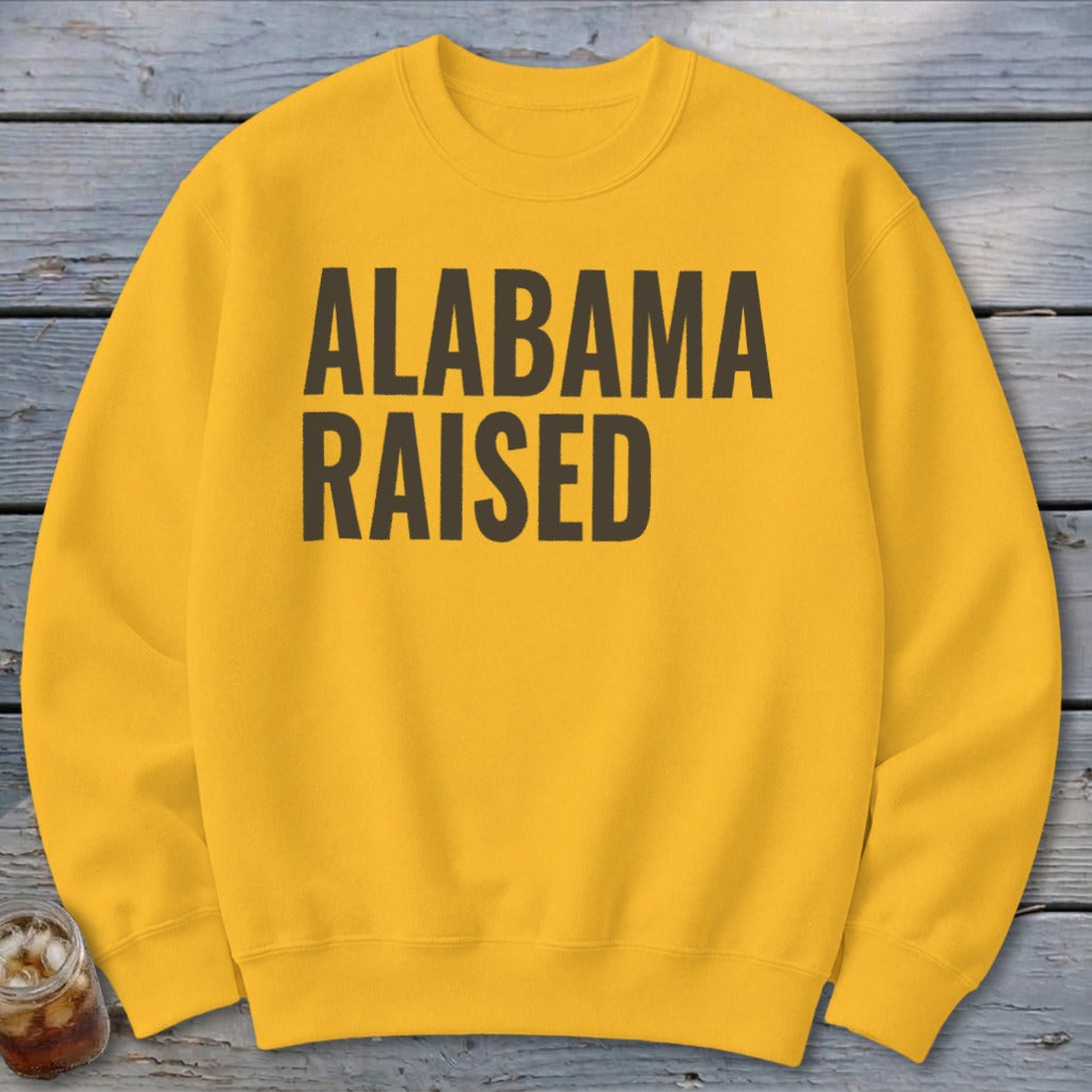 Yellow crewneck sweatshirt with "Alabama Raised" text in dark brown.