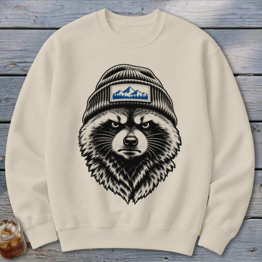 Cream sweatshirt featuring a black and white illustration of a raccoon wearing a beanie with a mountain patch.