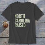 Dark grey V-neck t-shirt with "NORTH CAROLINA RAISED" text in light green.