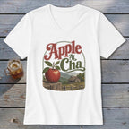 A white V-neck t-shirt featuring a retro graphic of an apple, a rustic cabin, and the text Apple At Cha.