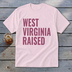 Pink t-shirt with "WEST VIRGINIA RAISED" text in maroon.