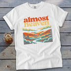 White t-shirt with "Almost Heaven" text and a colorful landscape graphic.
