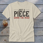 Cream t-shirt with text "JUST A PIECE DOWN THE ROAD"