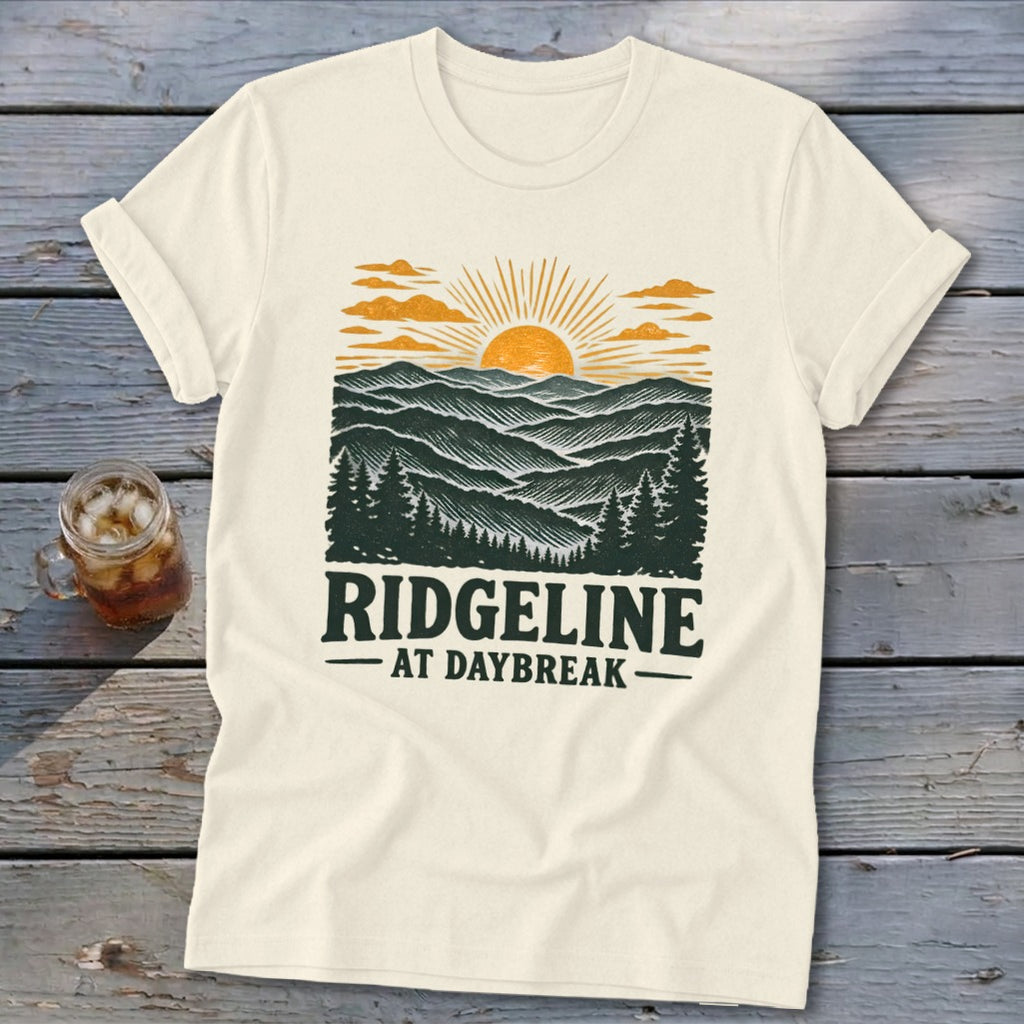 Cream t-shirt with "Ridgeline at Daybreak" text and a sunrise mountain landscape design.
