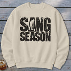 A cream crewneck sweatshirt featuring a distressed black graphic with the text SANG SEASON.
