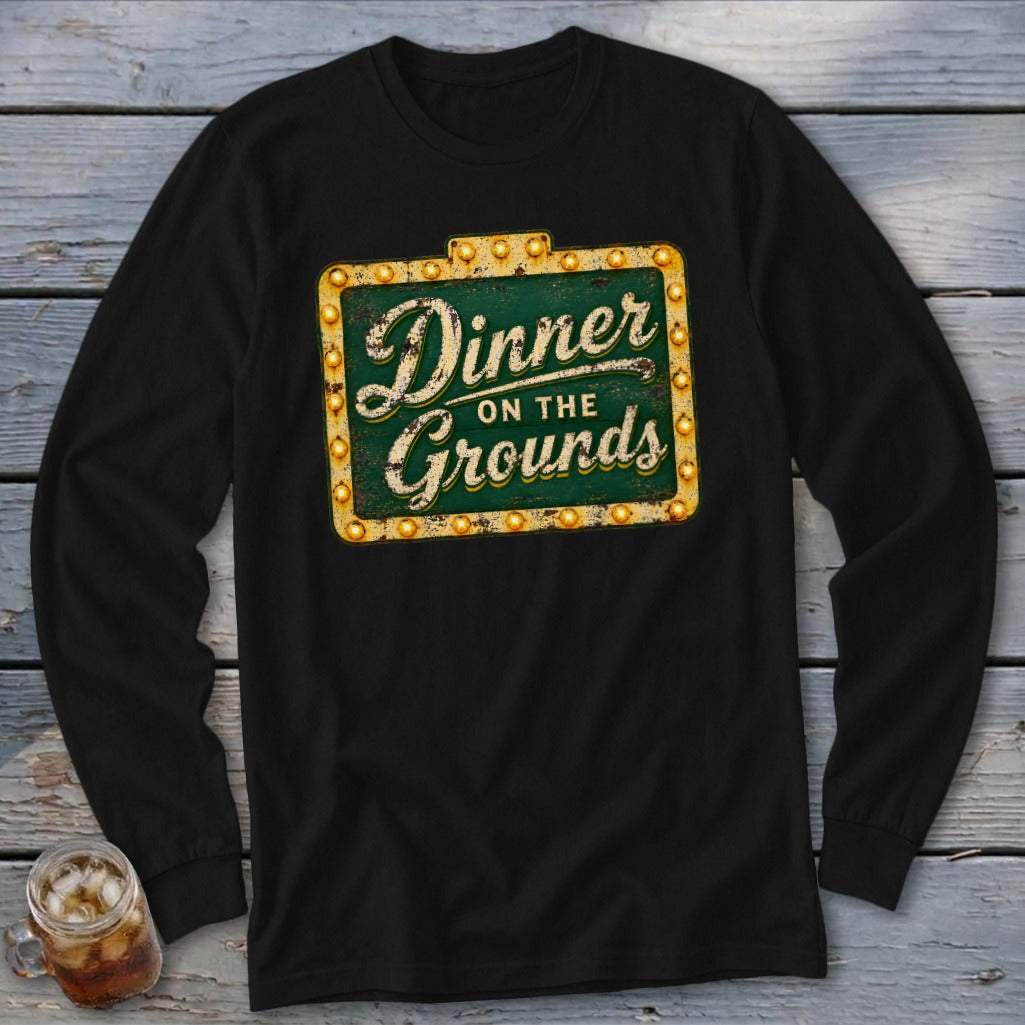 Black long-sleeve t-shirt with a vintage-style green sign graphic reading Dinner on the Grounds.