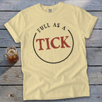 Light yellow t-shirt with "FULL AS A TICK" text inside a circle.