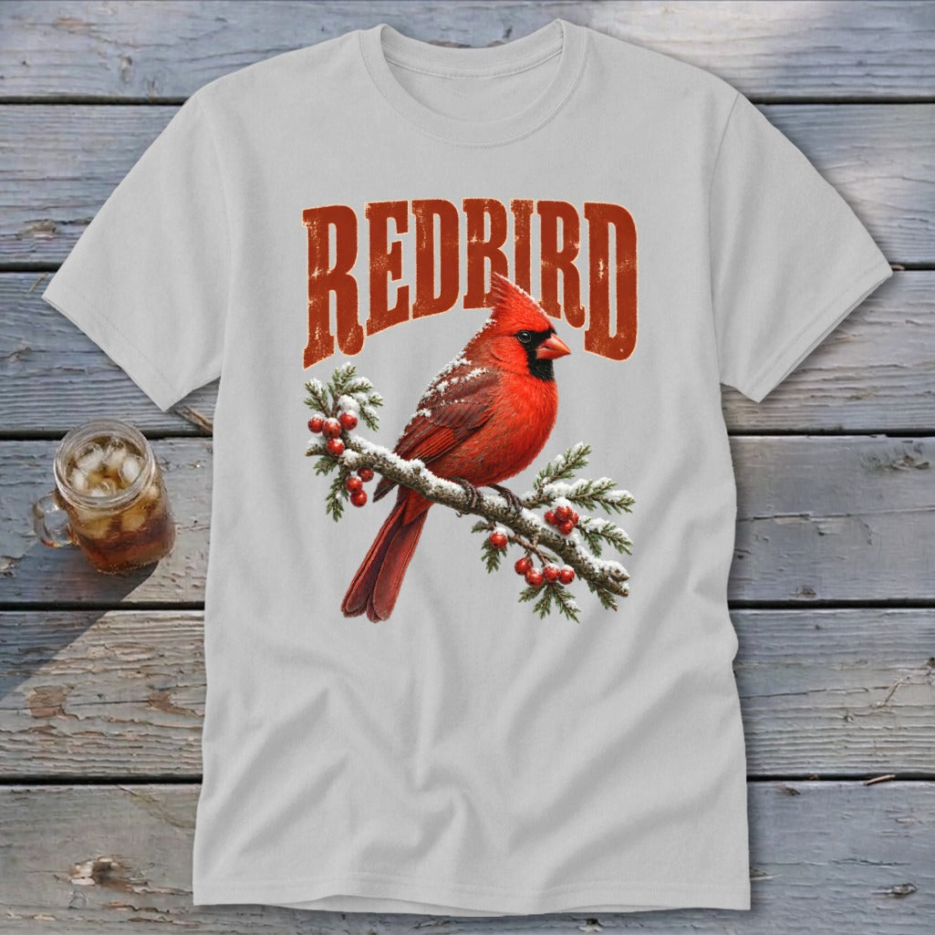 A light gray t-shirt featuring a graphic of a red cardinal on a snowy branch with the text "REDBIRD".
