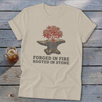 T-shirt with anvil, growing plant, and "Forged in Fire Rooted in Stone" text.