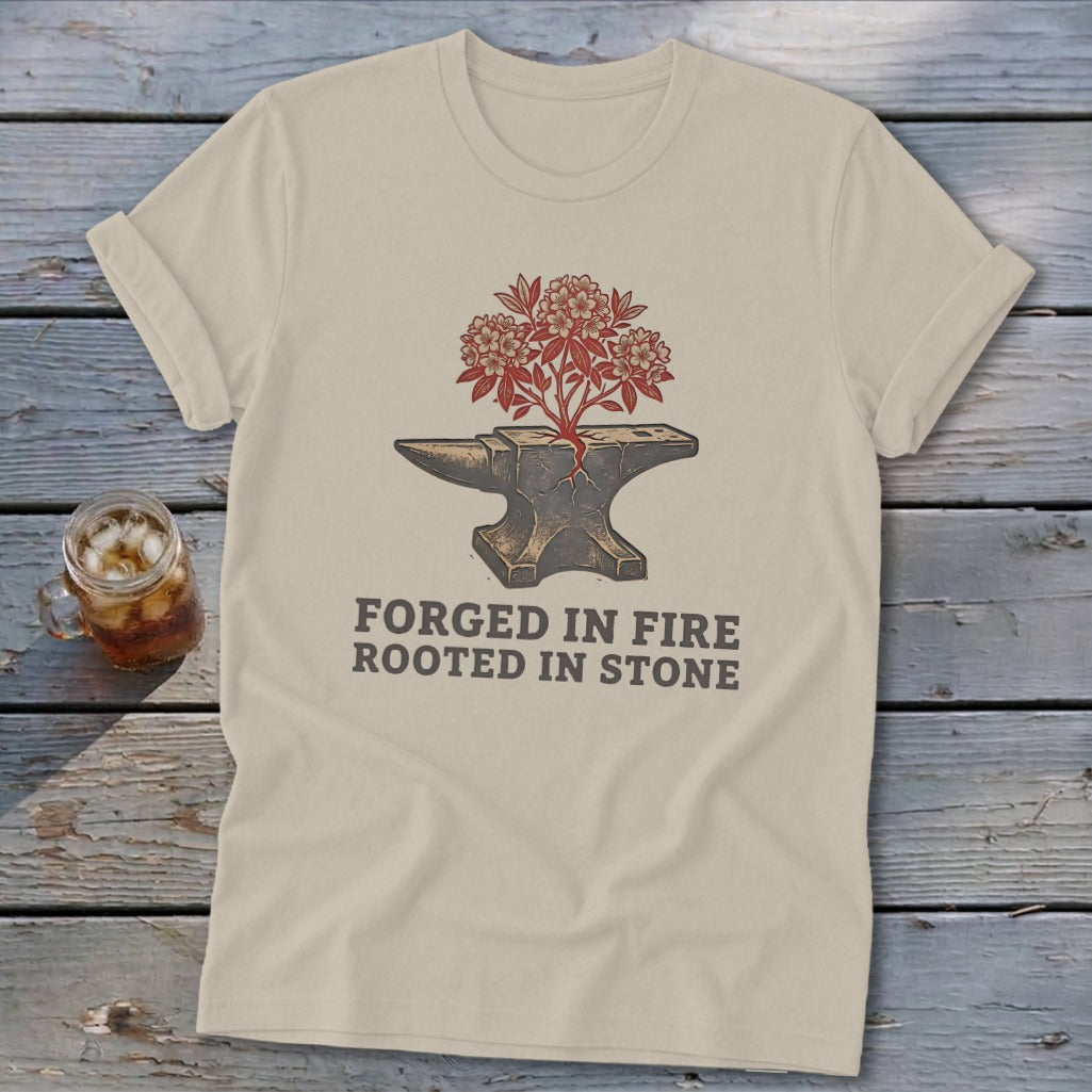 T-shirt with anvil, growing plant, and "Forged in Fire Rooted in Stone" text.