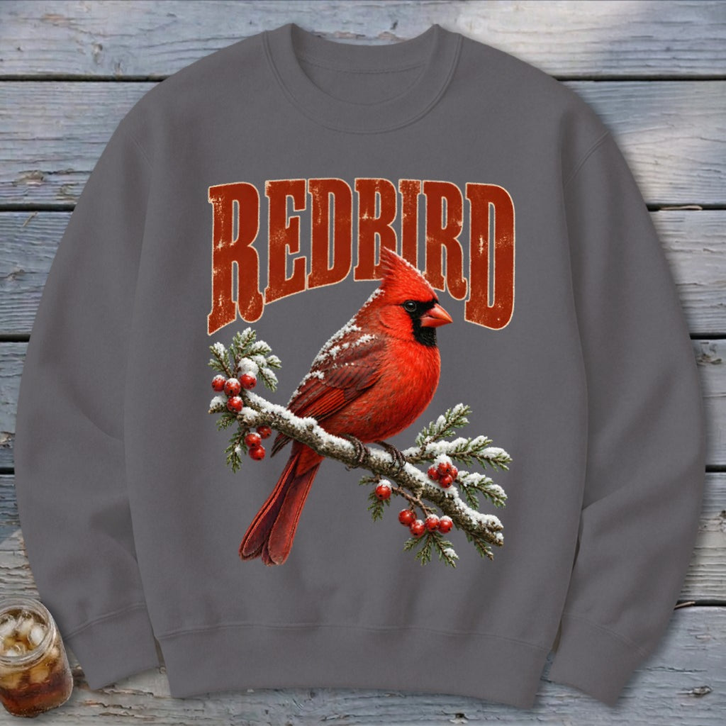 A dark gray crewneck sweatshirt featuring a red cardinal on a snowy branch and the text Redbird.