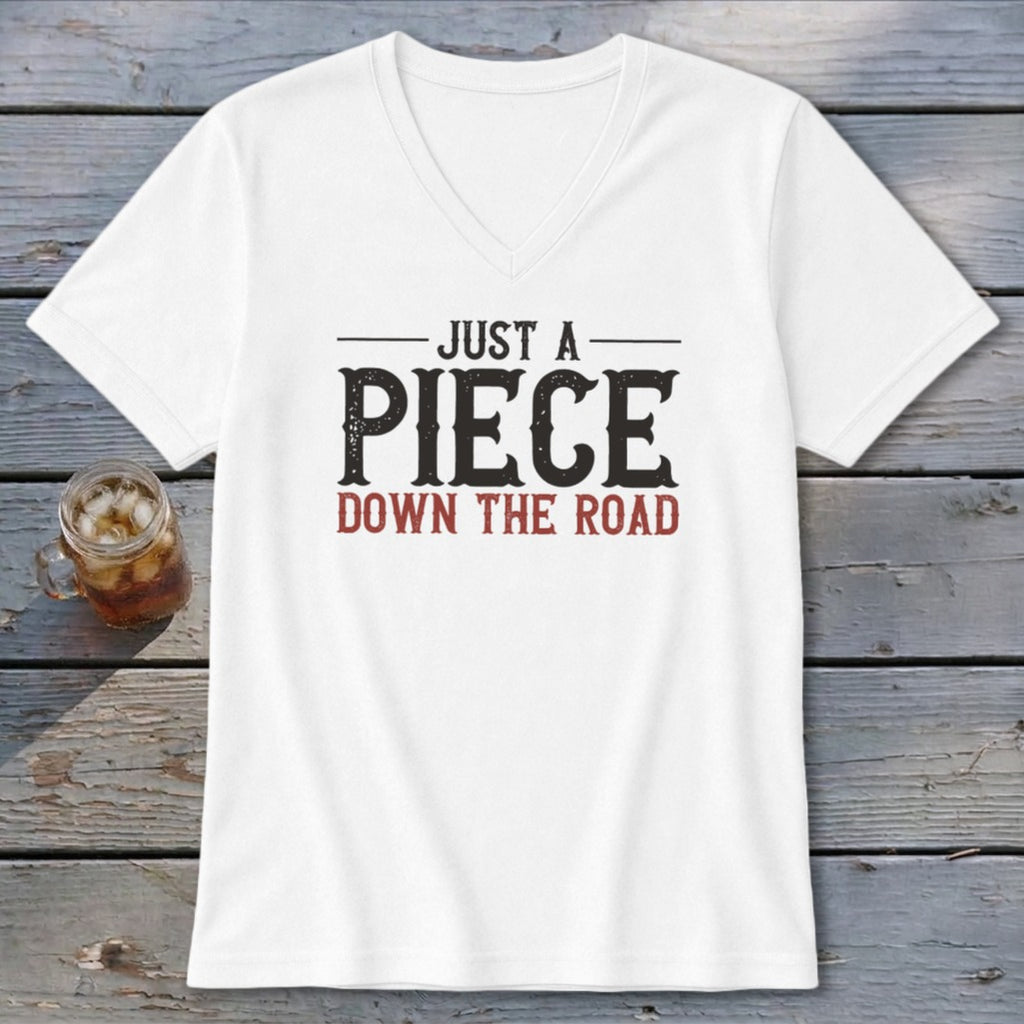 White v-neck t-shirt with distressed text that reads "JUST A PIECE DOWN THE ROAD".