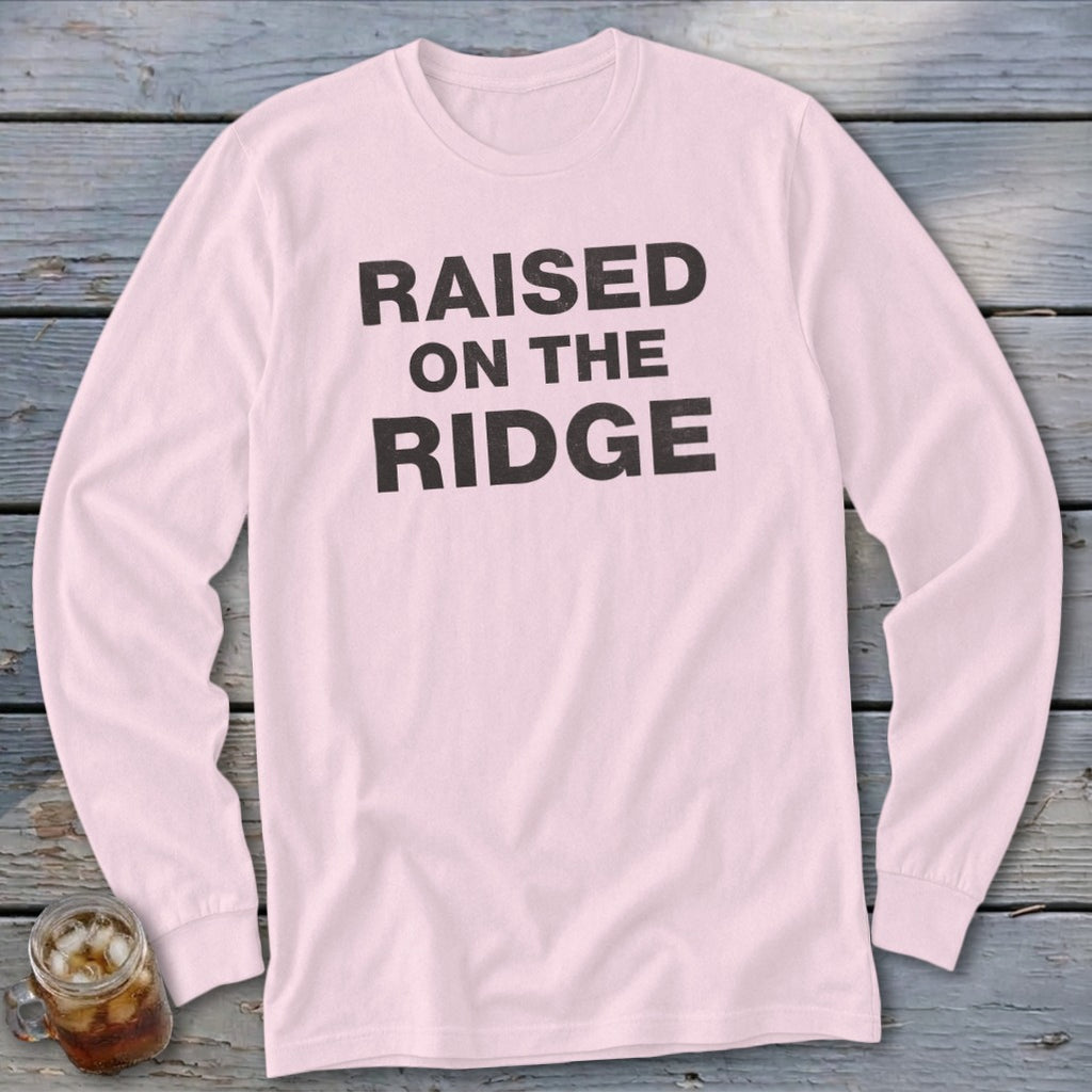 Pink long-sleeve shirt with black text reading "RAISED ON THE RIDGE".