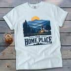 White t-shirt with "The Home Place" text over a landscape of a house and mountains.