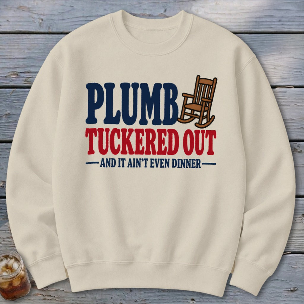 Cream sweatshirt with "Plumb Tucker Out" and a rocking chair graphic.