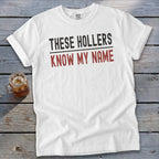 White t-shirt with "THESE HOLLERS KNOW MY NAME" text in black and red.